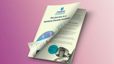 A4 booklet called The Journey to a Dyslexia-Friendly Scotland, the front cover peeling back to reveal an inner page of text.