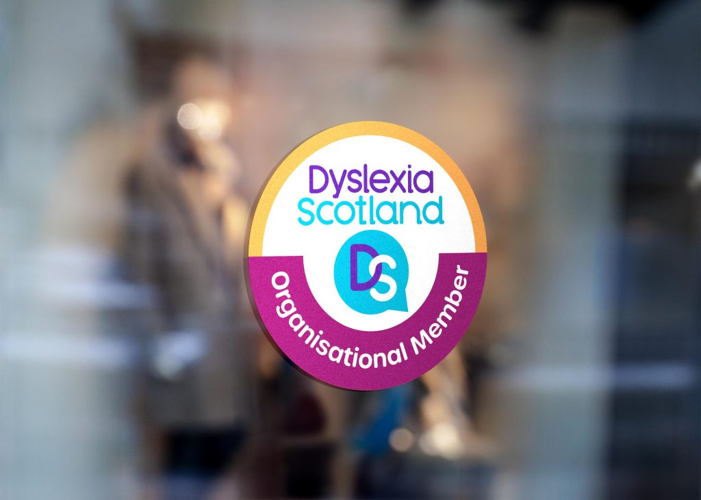 The Dyslexia Scotland Organisational Member badge displayed on the glass door of a business frontage.