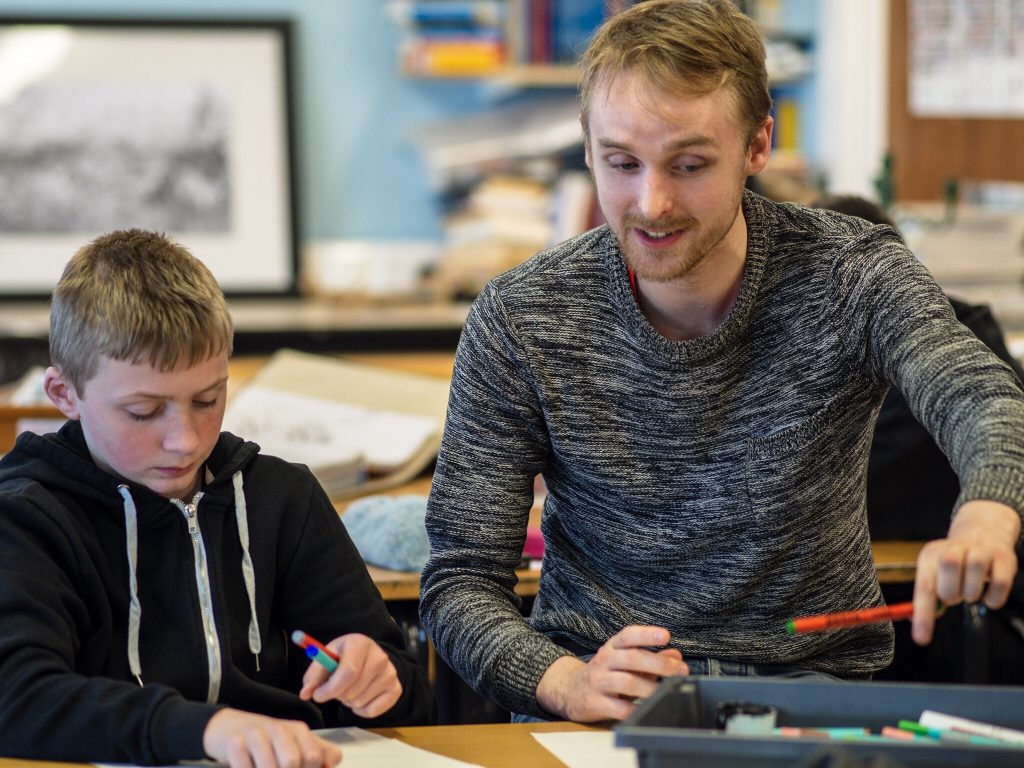 Dekko Comics' founder Rossie Stone with a young person, drawing.