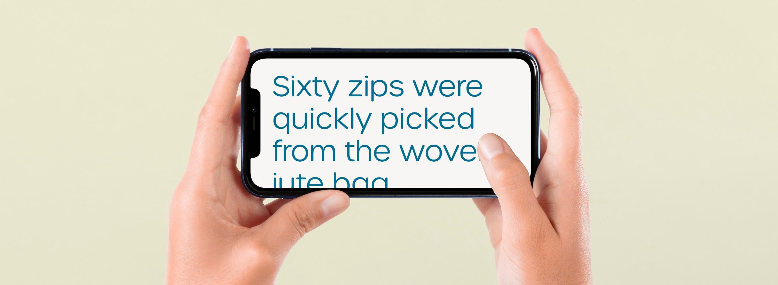 Hands hold up a mobile phone in landscape format. On screen there is large, teal-coloured text on a beige background. The text reads, 'Sixty zips were quickly picked form the woven jute bag.'