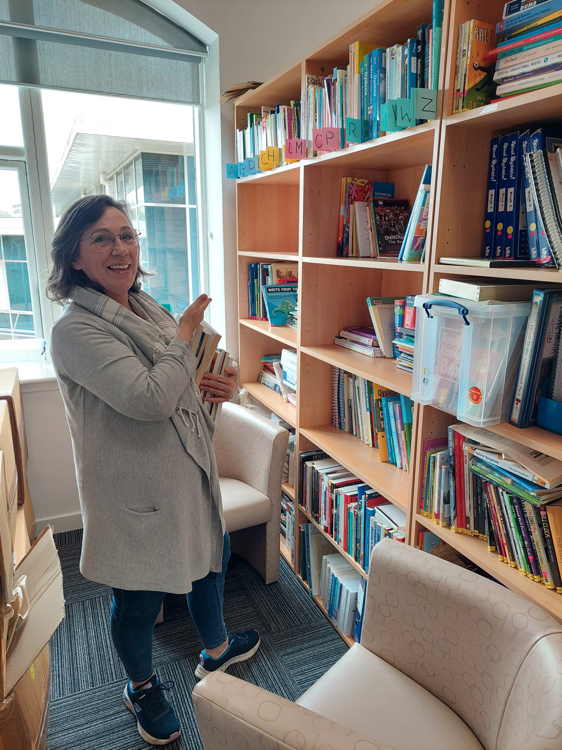 Volunteer Terri at a shelf of books