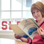 Cathy Magee reading a copy of Dyslexia Scotland's strategic plan.