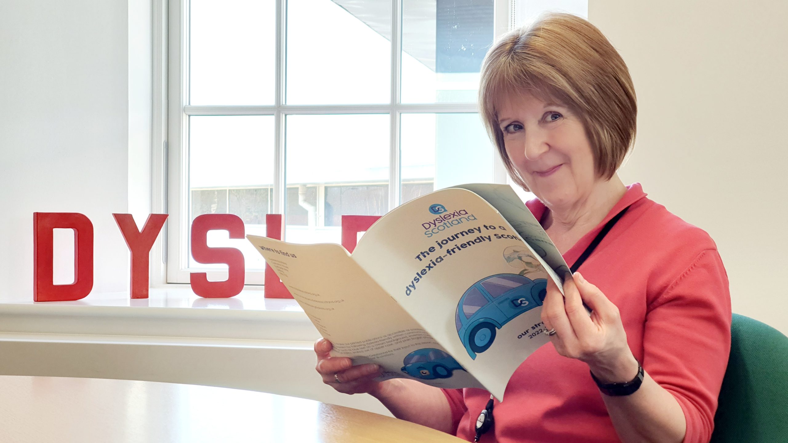 Cathy Magee reading a copy of Dyslexia Scotland's strategic plan.