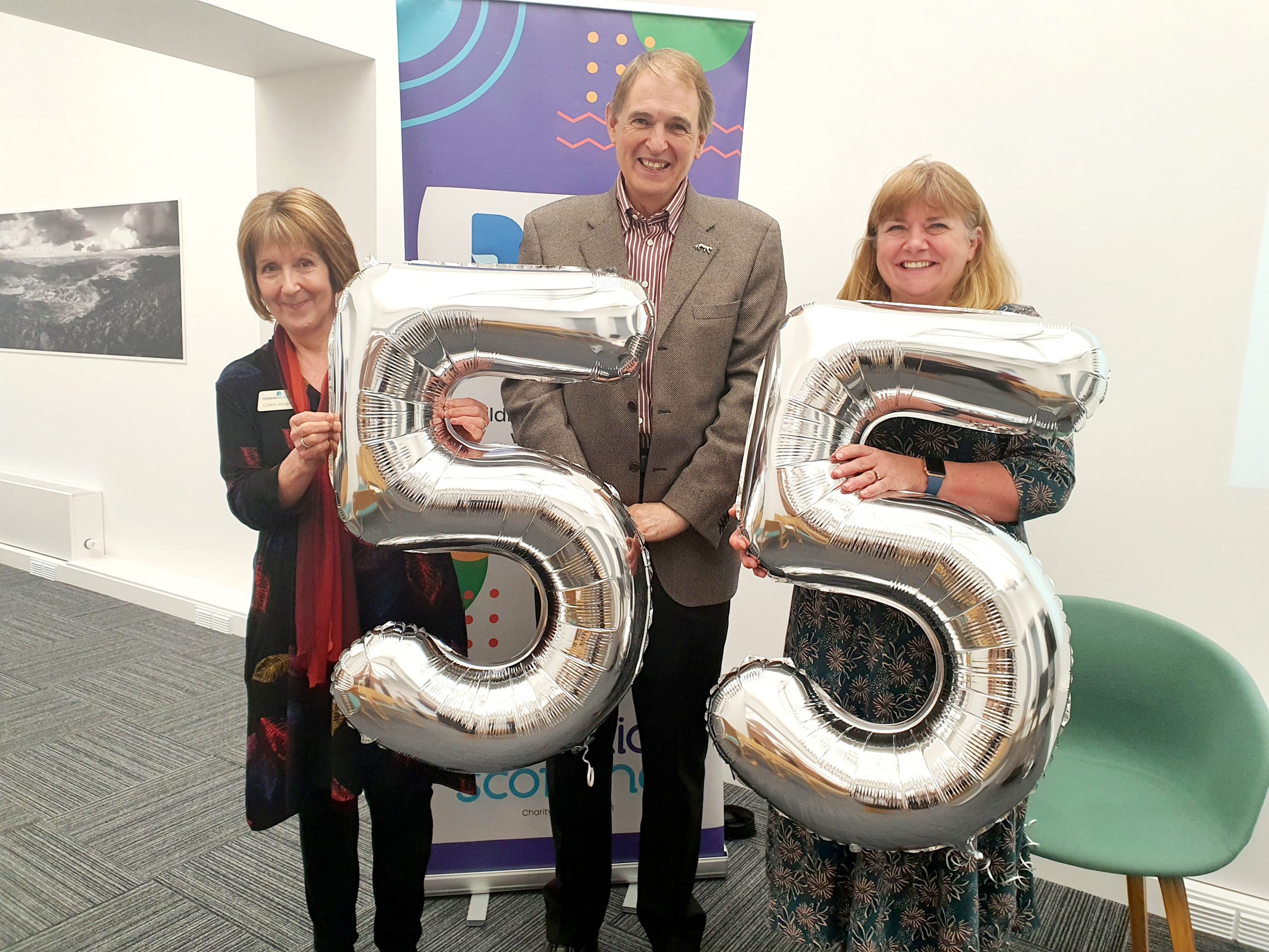 Representatives of Dyslexia Scotland hold balloons in the shape of '55'