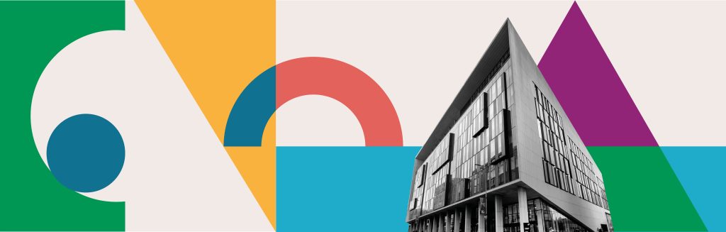 Conference venue set against a backdrop of geometric building-block shapes morphing together.