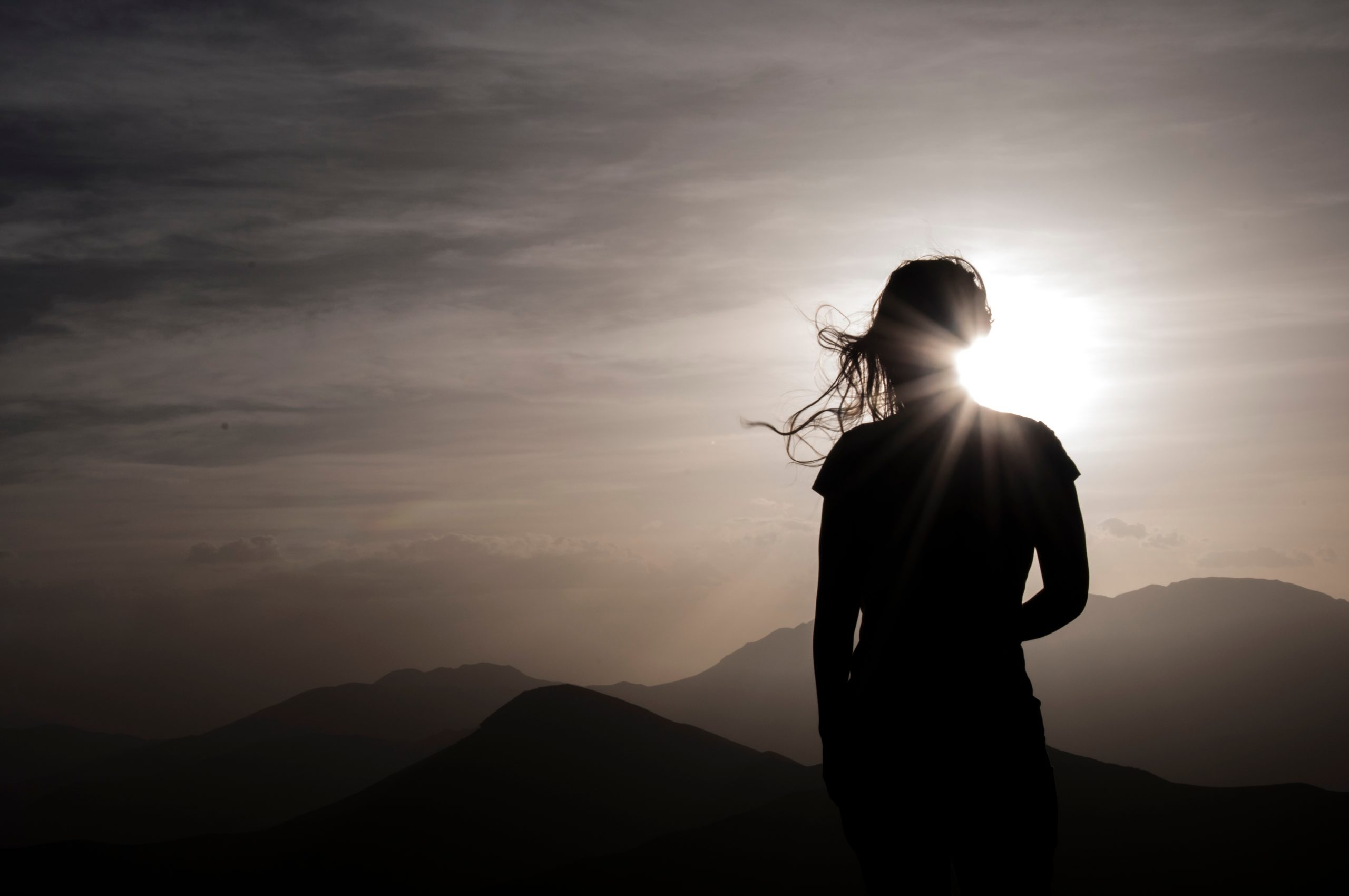 A woman silhoutted against a sunrise