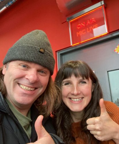 Dyslexia Scotland Ambassador Jen and Film Maker Trevor smile and give a thumbs up outside a radio studio.