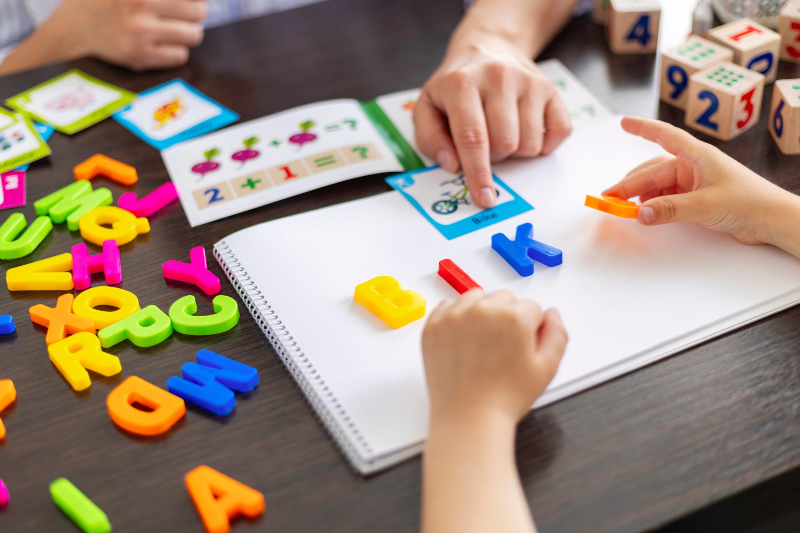 A child uses magnetic letters to spell the word 