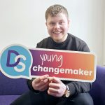 Young Ambassador Marc holding a Young Changemaker sign