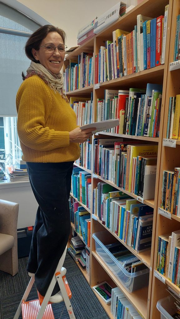 Library volunter at a book shelf