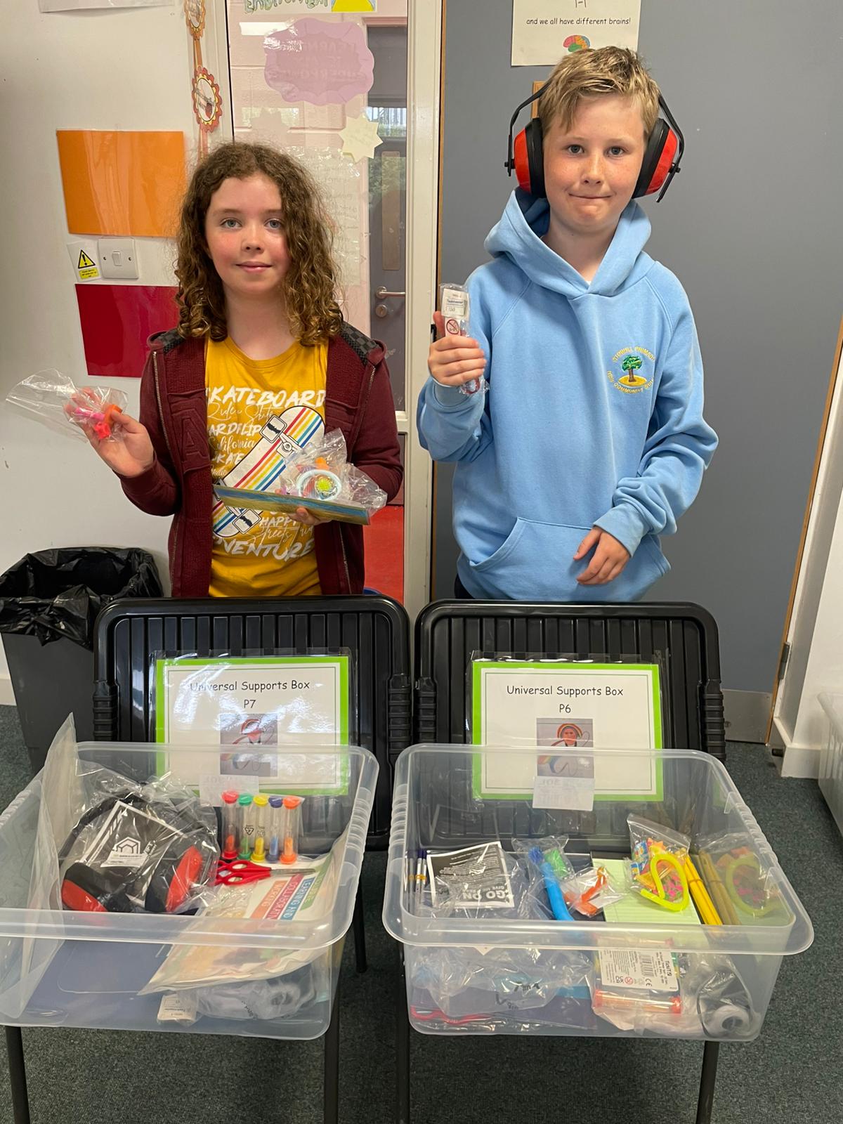 Two young people with boxes of resources
