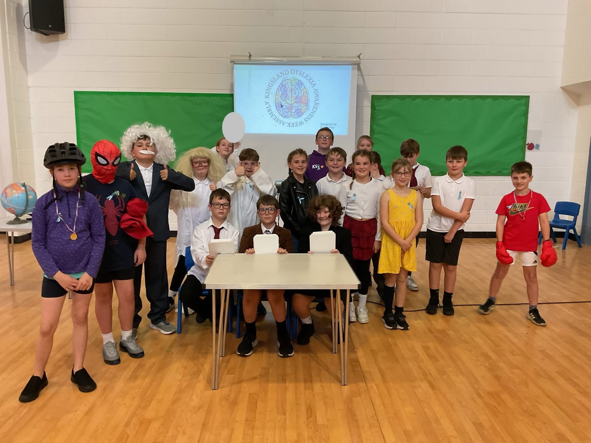 Young people stand in a group in their school assemble hall