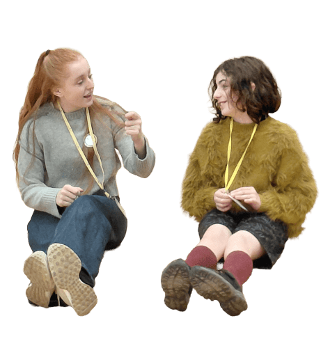 Two young women sit engaged in conversation.