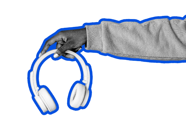 A hand holds out a pair of headphones