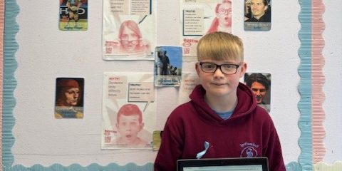 Harry in front of his school notice board.